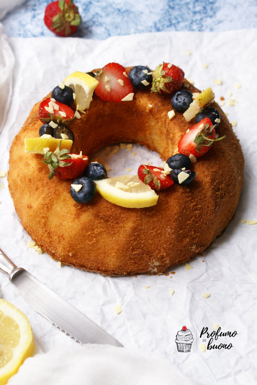 Ciambella al cucchiaio senza glutine con frutta fresca, spicchi di limone e scaglie di cioccolato bianco