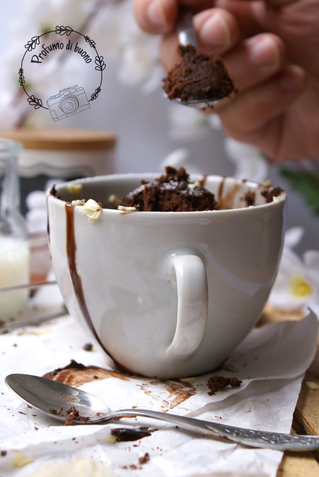 Mug Cake o torta in tazza senza glutine al cioccolato, con cioccolato fuso, zucchero a velo e scaglie di cioccolato bianco in superficie 