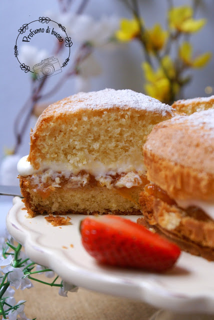 Fetta di Victoria Sponge Cake senza glutine con farine naturali farcita con crema di yogurt e panna e marmellata di albicocche. Servita con una spolverata di zucchero a velo e fragole fresche.