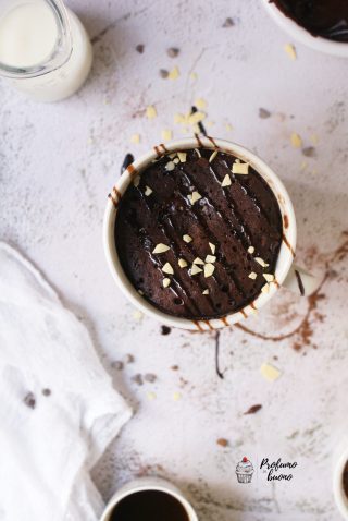 Torta in tazza senza glutine vegan al cioccolato, con cioccolato fuso e scaglie di cioccolato bianco in superficie