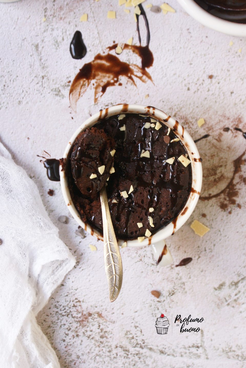 Torta in tazza senza glutine vegan al cioccolato, con cioccolato fuso e scaglie di cioccolato bianco in superficie