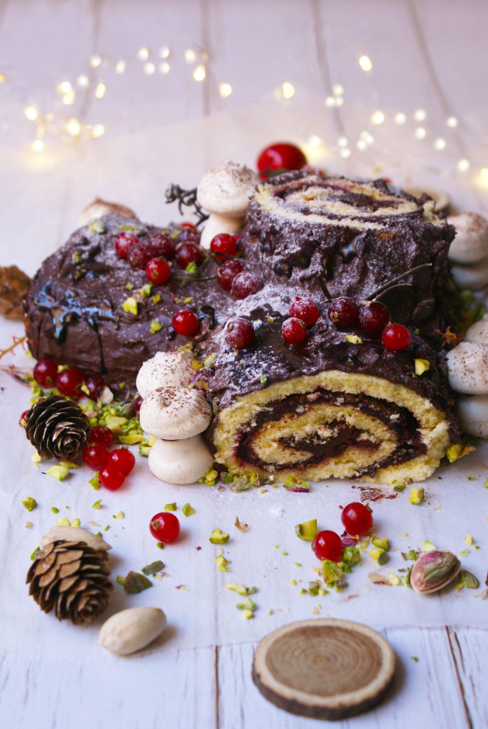 Tronchetto di Natale senza glutine ricoperto di ganache al cioccolato, zucchero a velo e ribes rosso