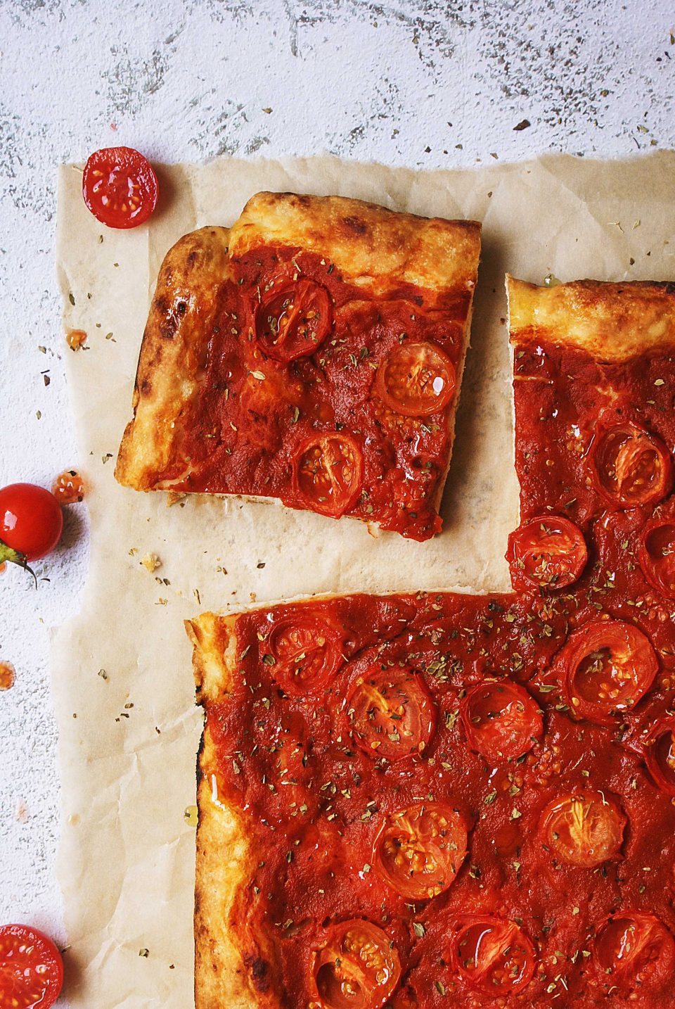 Pizza senza glutine in teglia con salsa di pomodoro, pomodorini e origano