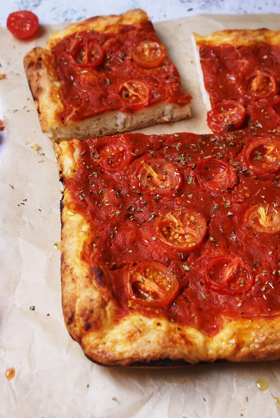 Pizza senza glutine in teglia con salsa di pomodoro, pomodorini e origano