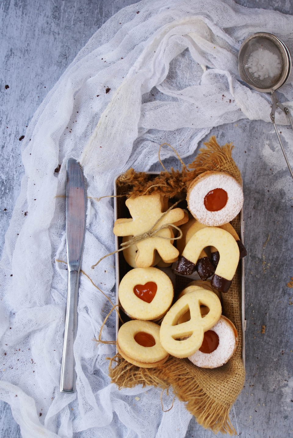 Biscotti di pasta frolla senza glutine con farine naturali ripieni di marmellata di amarene e ricoperti di cioccolato fondente e  zucchero a velo