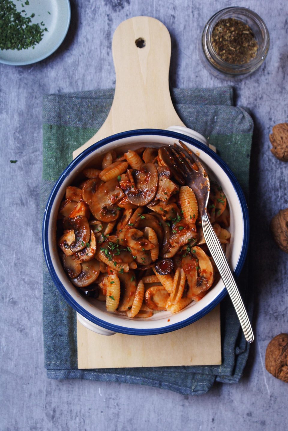 Pasta con funghi e pomodoro, olive nere e prezzemolo